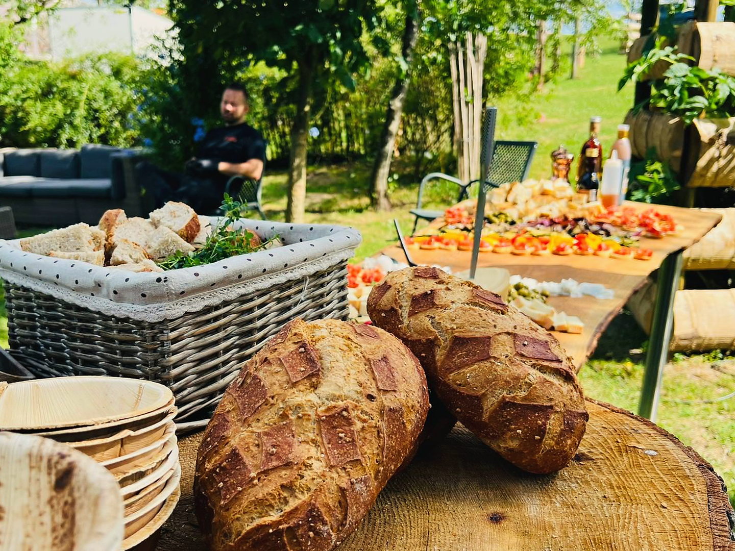 Gartenbuffet mit frischem Brot, Brotkorb und gedecktem Apéro-Tisch im Grünen
